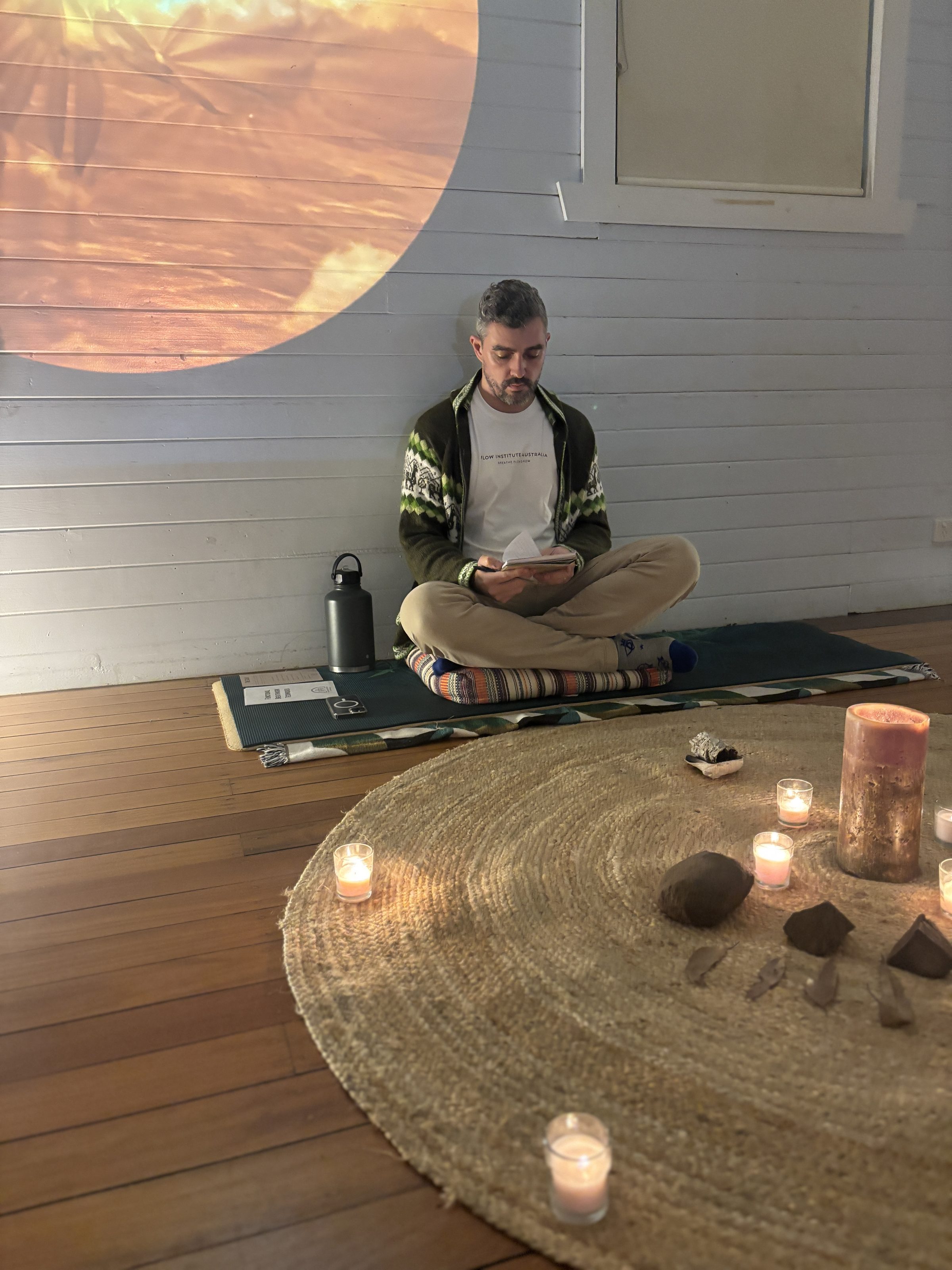 Max Latimer seated before a breathwork session, candles arranged in a circle