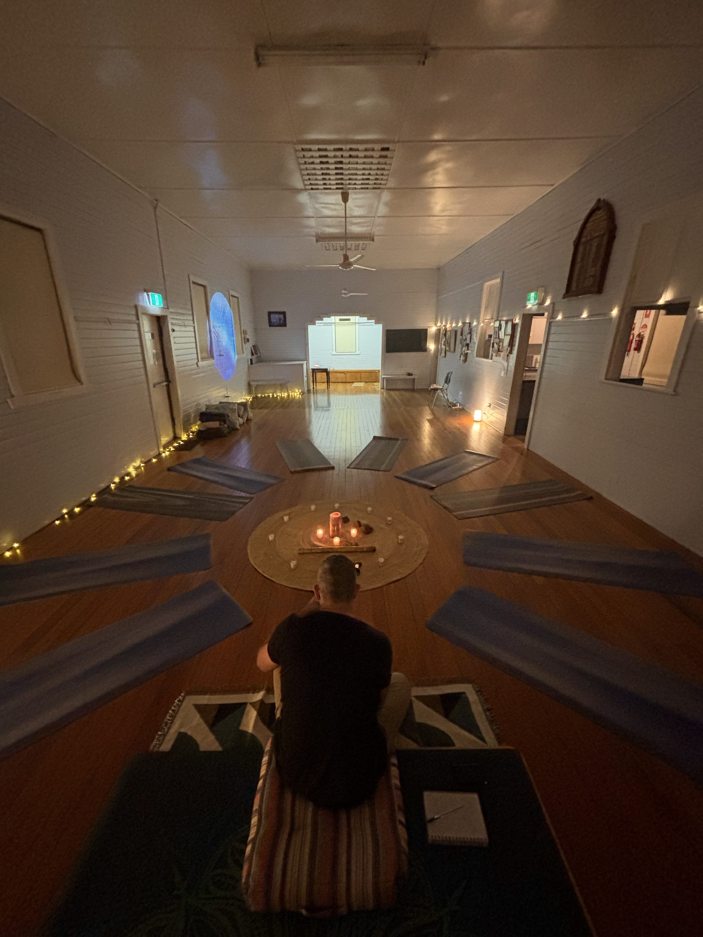 McLeans Ridges Community Hall set up for breathwork — mats in a sunburst, candles at the centre